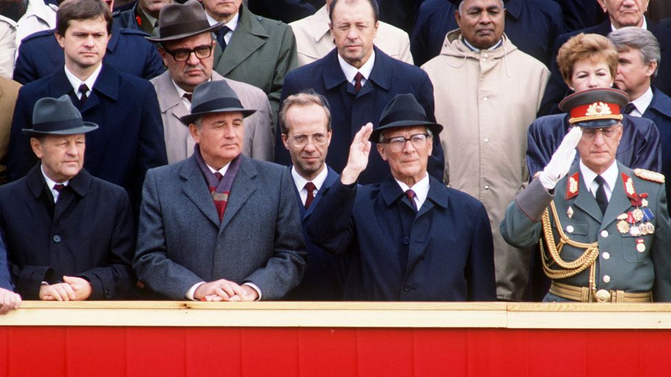 Erich Honecker (2.v.r.vorn), steht salutierend hinter einer Bruestung auf einer Tibuene, bei Parade zur "40-Jahre-DDR-Feier". Links neben ihm steht nachdenklich Michail GORBATSCHOW, Staats-und Parteichef der Sowjetunion. (Quelle: dpa)