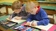 Symbolbild: Grundschulkinder in der Schule - ein Linkshänder schreibt im Klassenzimmer neben einem Rechtshänder etwas ins Schulheft. (Quelle: dpa/F. May)