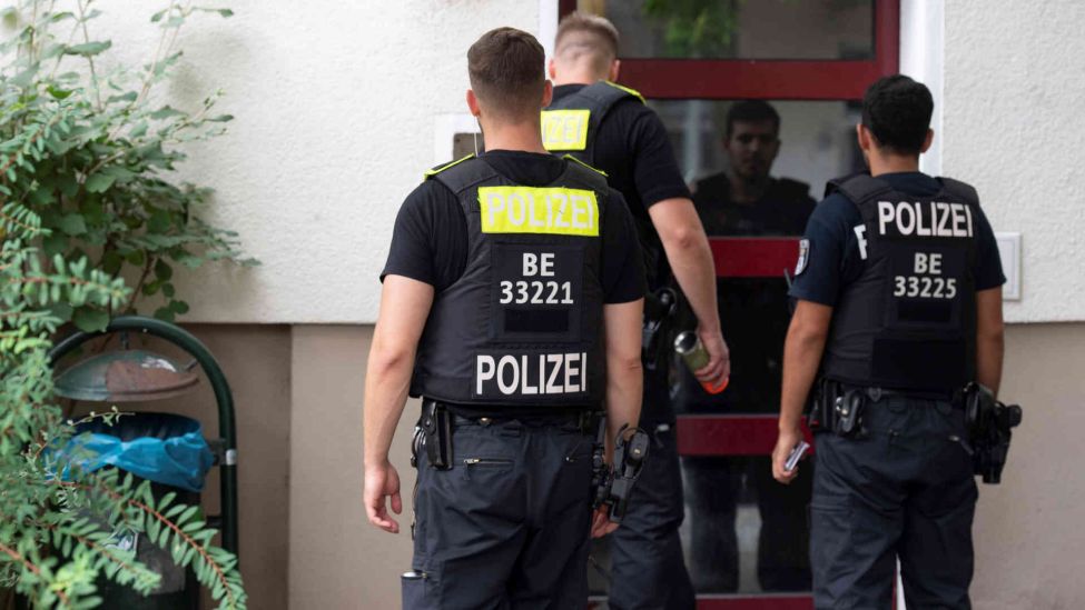 Polizeibeamte betreten unweit des Ostkreuzes ein Wohnhaus um die Bewohner zum Verlassen ihrer Wohnungen aufzufordern.