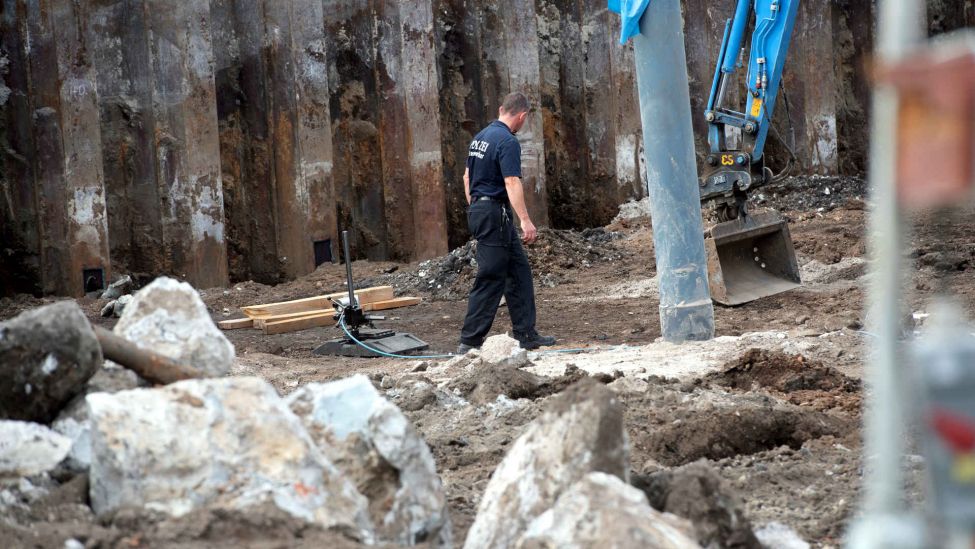 Ein Feuerwerker der Polizei geht unweit des Ostkreuzes auf einer Baustelle. Dort wurde bei Baggerarbeiten eine 500-Kg-schwere amerikanische Fliegerbombe gefunden. (Foto: Paul Zinken/dpa)