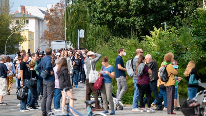 Zahlreiche Menschen stehen im September 2021 in einer langen Schlange vor den Wahllokalen im Tiergarten Gymnasium in der Altonaer Straße (Bild: dpa/Monika Skolimowska)
