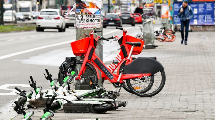 Umgefallene, nicht genutzte E-Scooter und abgestellte E-Bikes auf einem Gehweg am Alexanderplatz (Bild: dpa/Jens Kalaene)