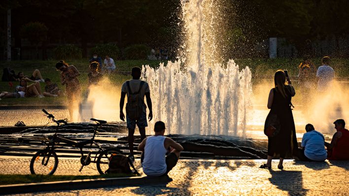 Menschen bei dem Brunnen im Lustgarten auf der Museumsinsel in Berlin am 20. Juli 2022. (Quelle: imago images)