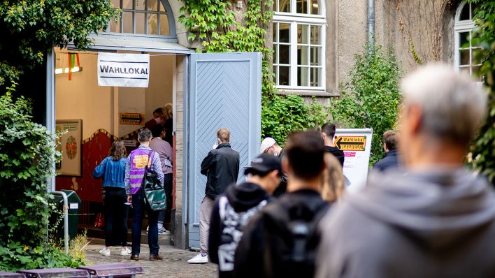 Zahlreiche Wählerinnen und Wähler warten am Wahlsonntag 2021 im Bezirk Prenzlauer Berg in einer langen Schlange vor einem Wahllokal, das in einer Grundschule untergebracht ist.