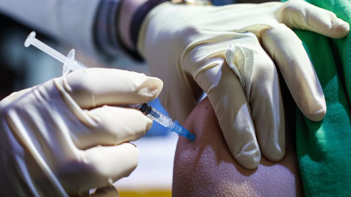 Symbolbild: Eine Frau bekommt ihre Covid-19-Impfung (Quelle: dpa/Abdulhamid Hosbas)