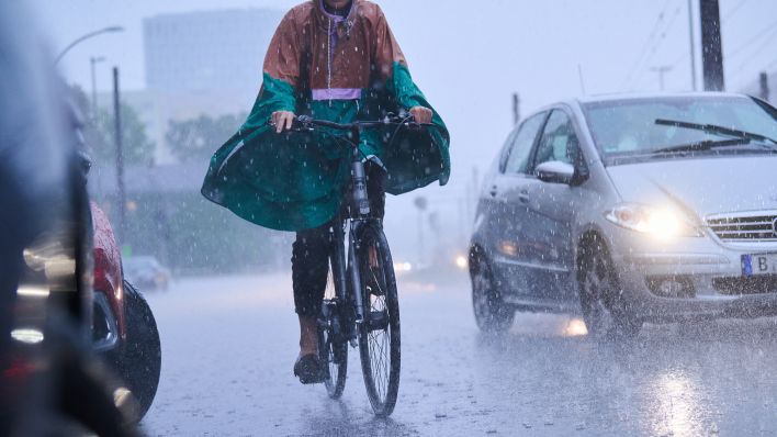 Symbolbild: Radfahrer fahren am 26.08.2022 bei starkem Regen durch Berlin (Quelle: dpa/Annette Riedl)
