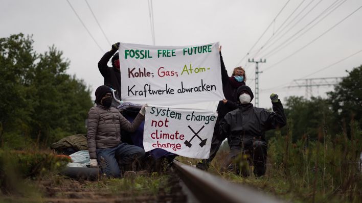 Klimaaktivisten der Gruppe "unfreiwillige Feuerwehr" blockieren am 19.09.2022 Gleise am Kohlekraftwerk Jänschwalde (Quelle: dpa/Lena Werres)