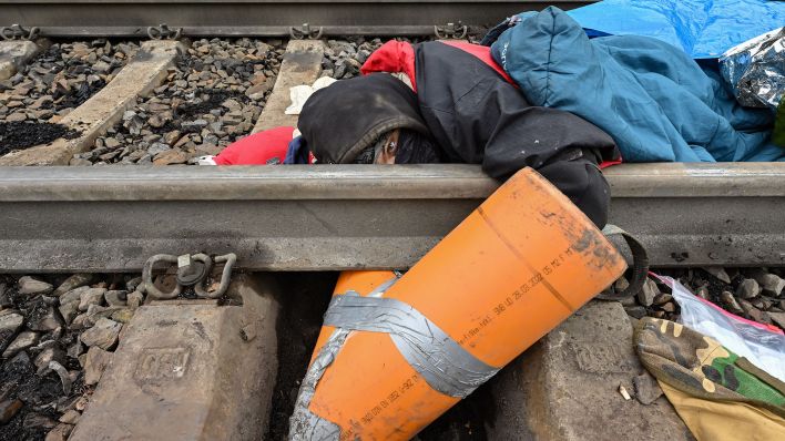 Eine Klimaaktivistin blockiert eine Gleisverbindung für den Transport von Braunkohle zum Kraftwerk Jänschwalde (Quelle: dpa/Patrick Pleul).
