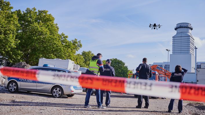 Polizisten stehen am 26.09.22 hinter einer Absperrung auf der Baustelle in Berlin-Moabit, wo eine Weltkriegsbombe gefunden wurde (Quelle: dpa/Annette Riedl)