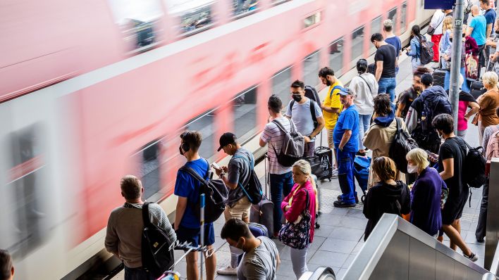 Fahrgäste steht am Berliner Bahnhof Ostkreuz am Bahnsteig, während ein Zug einfährt (Bild: dpa/Christoph Soeder)