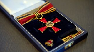 Das Bundesverdienstkreuz in einer Schatulle auf einem Tisch liegend.(Quelle:dpa/B.Pedersen)