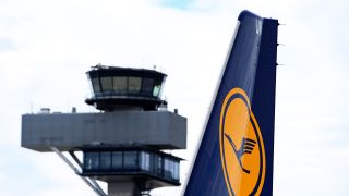 Das Logo am Leitwerk einer Lufthansa-Maschine ist auf dem Flughafen Berlin Brandenburg vor der Kulisse des Tower zu sehen.(Quelle:dpa/S.Stache)