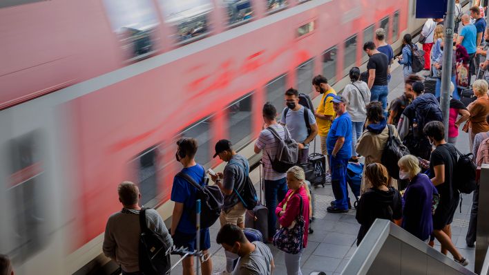 Archivbild: Fahrgäste steht am Berliner Bahnhof Ostkreuz am Bahnsteig, während ein Zug einfährt. (Quelle: dpa/C. Soeder)