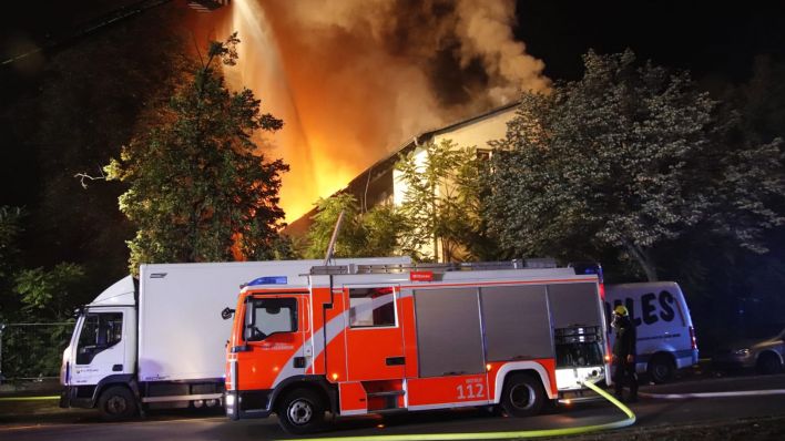 Vor einem brennenden Haus im Wedding steht ein Löschfahrzeug der Feuerwehr (Bild: Dominik Totaro)
