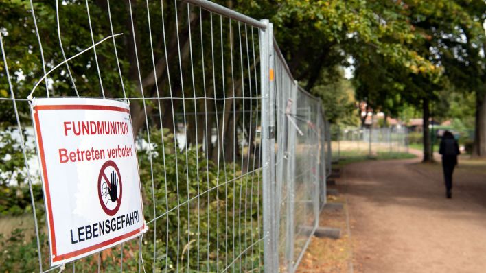 Ein Schild "Fundmunition Betreten verboten! Lebensgefahr" hängt an einem Metallzaun. (Quelle: dpa/Soeren Stache)
