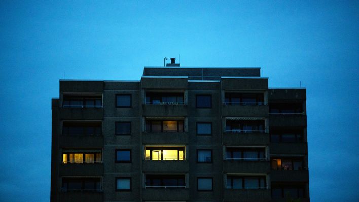 Symbolbild: Nur in einzelnen Wohnungen eines Mehrfamilienhauses brennt am frühen Morgen Licht. (Quelle: dpa/Julian Stratenschulte)