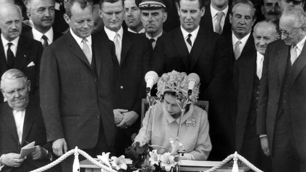 Archivbild: Königin Elizabeth II. trägt sich am 27.05.1965 vor dem Rathaus Schöneberg in Berlin in das Goldene Buch der Stadt ein. (Quelle: dpa)