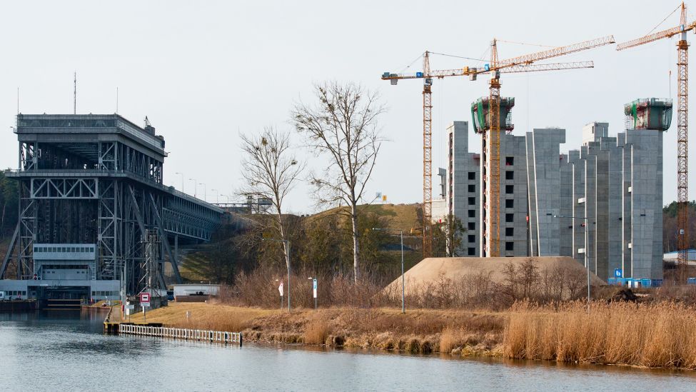 Archivbild: Etwa 50 Meter hohe Betonpfeiler ragen am 17.02.2014 aus dem Fundament der Baustelle (r) für das neue Schiffshebewerk in Niederfinow (Brandenburg), daneben (l) ist das alte Hebewerk zu sehen. (Quelle: dpa/P. Pleul)