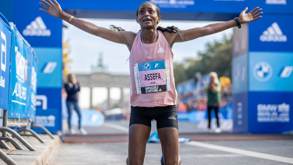 Tigist Assefa aus Äthiopien jubelt, nachdem sie beim BMW Berlin Marathon nach 2:15:37 Stunden als erste Frau durchs Ziel lief. (Quelle: dpa/A. Gora)