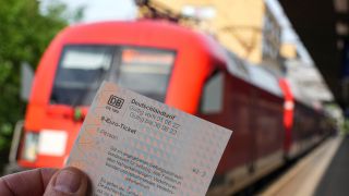 Archivbild: Die Hand eines Mannes hält auf dem Potsdamer Hauptbahnhof ein 9-Euro-Ticket. (Quelle: dpa/S. Stache)