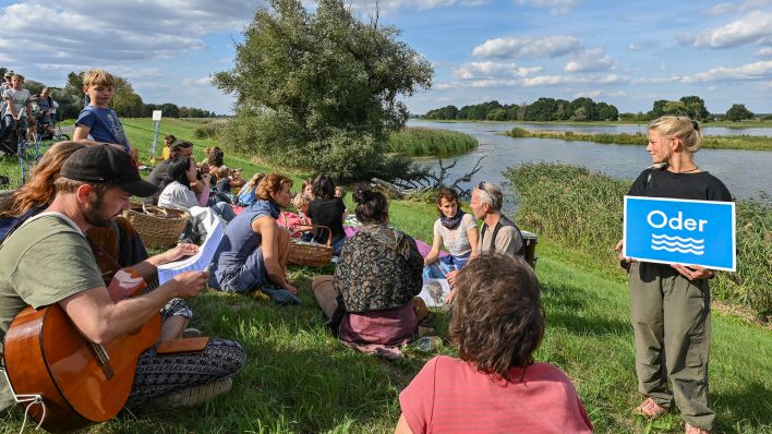 Personen nehmen an einer Veranstaltung der Kienitzer Bürgerinitiative «Save Oder Die» auf dem Deich am deutsch-polnischen Grenzfluss Oder teil. (Quelle: dpa/P. Pleul)