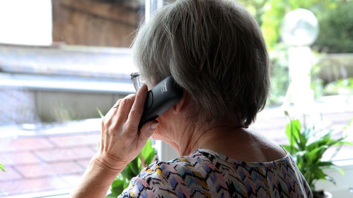 Symbolbild: Eine Seniorin telefoniert und blickt aus dem Fenster. (Quelle: imago images/Eibner)