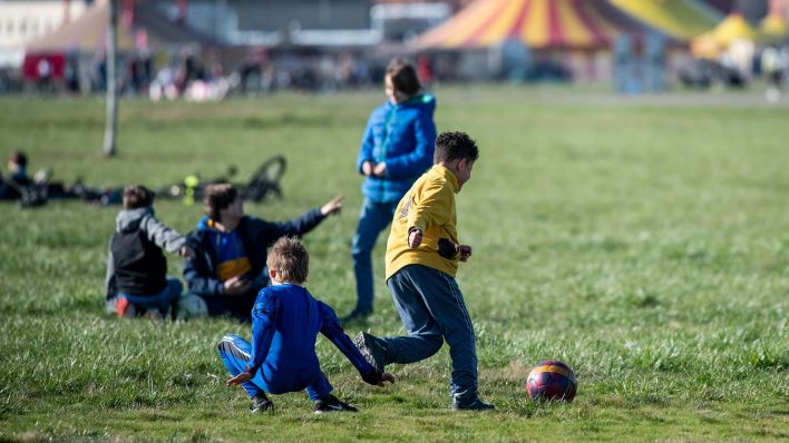 Kinder spielen gegen 15 Uhr auf dem Tempelhofer Feld Fußball. Bei frühlingshaftem Wetter sind viele Menschen unterwegs. (Quelle: dpa/Bernd von Jutrczenka)