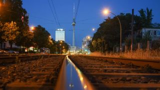 Bei Sonnenaufgang spiegelt sich in einem Tram-Gleis auf der Prenzlauer Allee der Fernsehturm (Quelle: dpa/Jörg Carstensen)