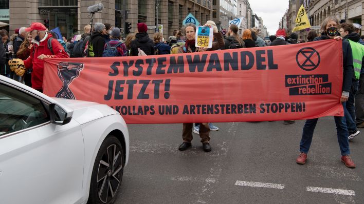 Aktivisten der Umweltschutzgruppe "extinction rebellion" stehen mit einem Transparent auf der Kreuzung Unter den Linden/Friedrichstraße (Quelle: dpa/Paul Zinken)