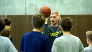 Basketballer Niels Giffely zeigt Kindern Wurfbewegung (Imago/Camera 4)