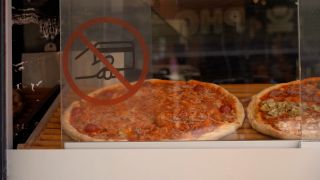 Am Schaufenster des Restaurants "Eatalian" ist eine durchgestrichene Geldkarte zu sehen. Dahinter liegen Pizzen. (Bild: rbb/Naomi Donath)