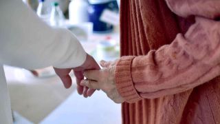 Archiv: Eine Pflegekraft hält die Hand einer Bewohnerin einer Pflegeeinrichtung. (Foto: Britta Pedersen/dpa)