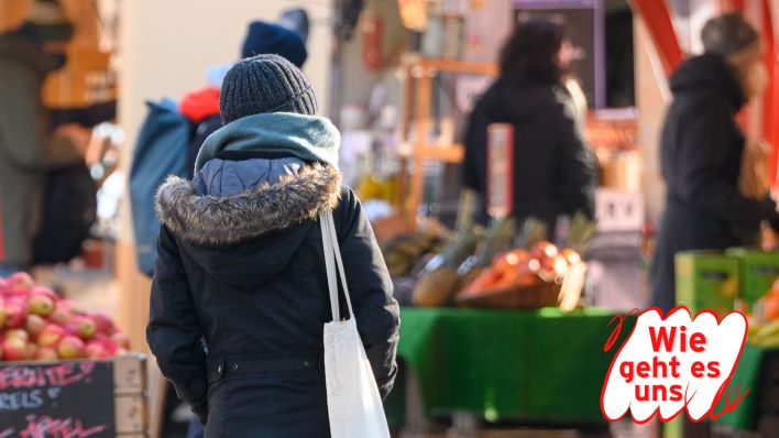 Symbolbild: Eine Frau geht an verschiedenen Marktständen und Aufstellern vorbei.. (Quelle: dpa/Jonas Walzberg)