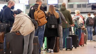 Reisende stehen am 17.10.2022 auf dem Flughafen Hamburg an einem Check-In-Schalter an. (Quelle: dpa/Bodo Marks)