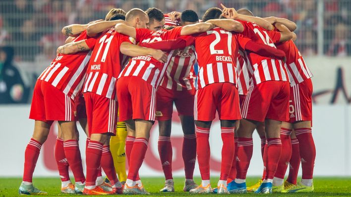 Das Team von Union Berlin steht am 19.10.2022 beim DFB-Pokalspiel gegen Heidenheim im Kreis zusammen (Quelle: dpa/Andreas Gora)