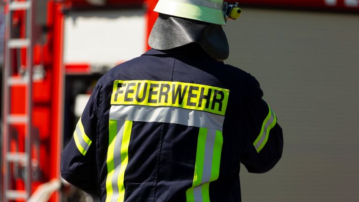 Symbolbild:Ein Feuerwehrmann mit Sicherheitshelm und dem Aufdruck Feuerwehr auf seiner Einsatzkleidung.(Quelle:dpa/Fotostand)