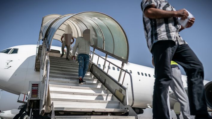 Archivbild: Männer gehen nach ihrer Abschiebung über die Gangway aus einem Charterflugzeug. (Quelle: dpa/M .Kappeler)