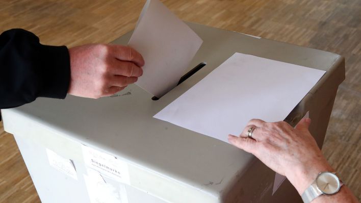 Eine Wählerin wirft ihren Wahlschein in einem Wahllokal in die Wahlurne. (Quelle: dpa/Bodo Schackow)