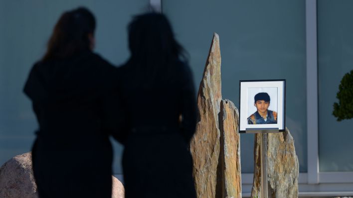 Archivbild: Vor Beginn einer Trauerfeier für Jonny K. gehen zwei junge Frauen am 28.10.2012 in Berlin an einem Bild des Jungen vorbei. (Quelle: dpa/Rainer Jensen)