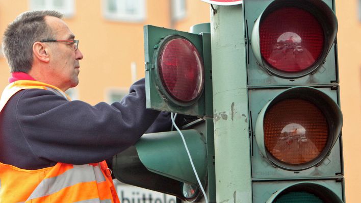 Symbolbild:Techniker repariert eine defekte Verkehrsampel an einer belebten Straﬂenkreuzung in Berlin.(Quelle:imago/R.Peters)