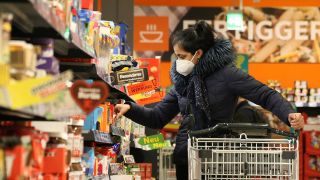 Symbolbild: Eine Frau trägt eine FFP2-Maske beim Einkaufen (Quelle: IMAGO/IPA Photo)