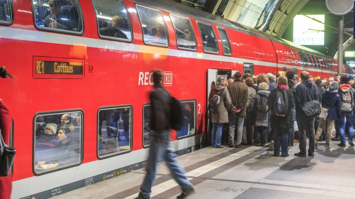 Symbolbild: Reisende am Berliner Hauptbahnhof steigen in einen DB Regio Express nach Cottbus. (Quelle: imago images/R. Weisflog)