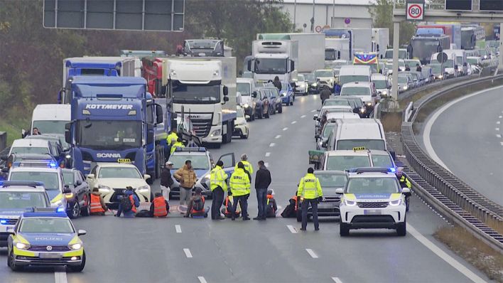 Polizeieinsatz auf der Autobahn, Aktivist:innen blockieren die Zufahrt zum Flughafen.(Quelle:TV News Kontor)