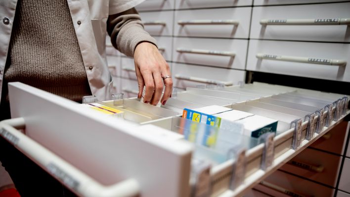 Symbolbild: Eine Apothekerin greift in einer Apotheke in eine Medikamentenschublade (Quelle: dpa/Christoph Soeder)