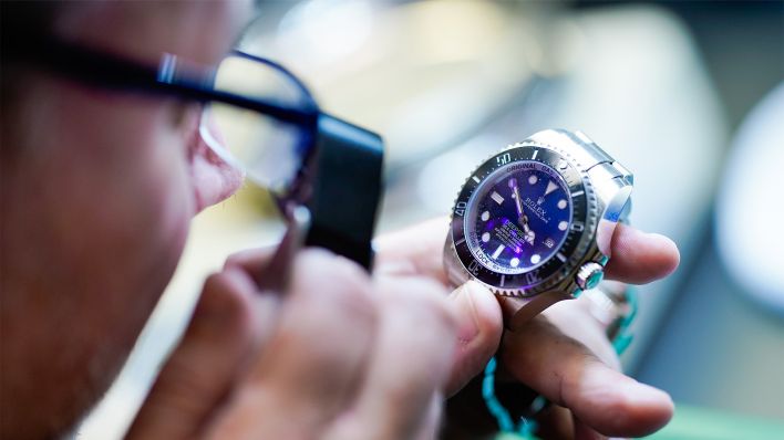 Bernd Barz, Filialleiter des „City Leihhaus“, überprüft am 17.10.2019 im Pfandleihhaus mit einer Lupe eine Uhr der Marke "Rolex". (Quelle: dpa/Uwe Anspach)