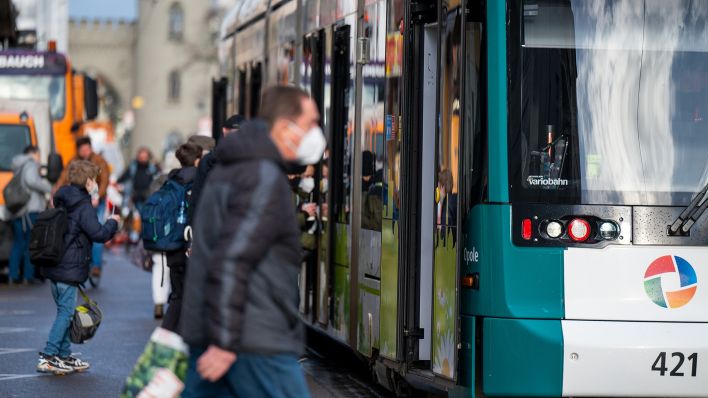 Archivbild: Fahrgäste mit FFP2-Masken steigen am 17.01.2022 in eine Straßenbahn in der Innenstadt ein. (Quelle: dpa/Monika Skolimowska)
