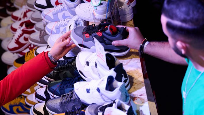 Symbolbild: Ein Verkäufer reicht einer Frau einen Sneaker über den Verkaufstisch im Festsaal Kreuzberg (Quelle: dpa/A.Riedl)