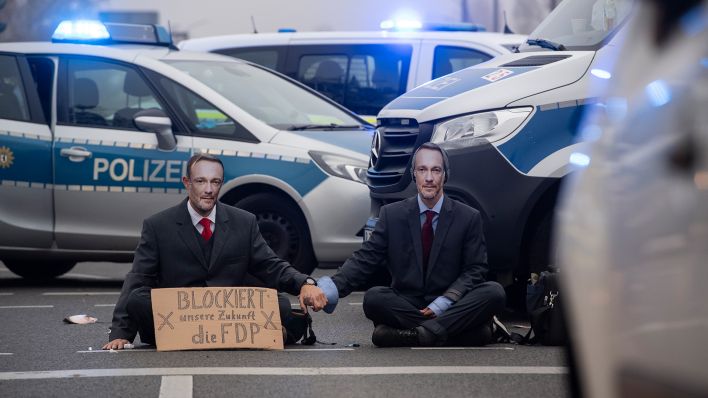 Aktivisten der Gruppe "Letzte Generation" sitzen am 16.11.22 auf einer Kreuzung an der Landsberger Allee (Quelle: dpa/Paul Zinken)