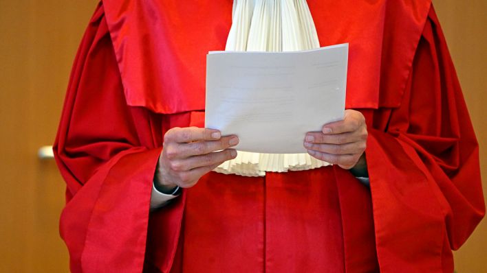Symbolbild:Ein Mitglied des Bundesverfassungsgericht hält ein Urteilspapier in den Händen.(Quelle:dpa/U.Deck)