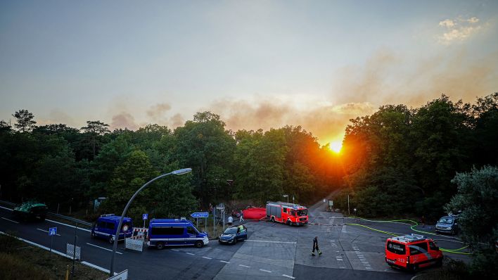 Archivbild:Die Sonne geht am 04.08.2022 hinter dem Rauch über der Einsatzleitstelle unter. Am Morgen ist ein Feuer auf dem Sprengplatz der Polizei im Grunewald ausgebrochen.(Quelle:dpa/K.Nietfeld)